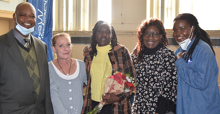 Regis Obijiski 2022 Scholarship Award Winner Lyndah Ouma (center) poses with family, friends and colleagues 